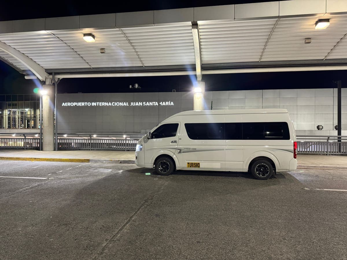 A Pick Me Up certified tourism van waiting outside the airport terminal at night